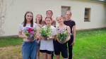 Młodzież z bukietami kwiatów 
